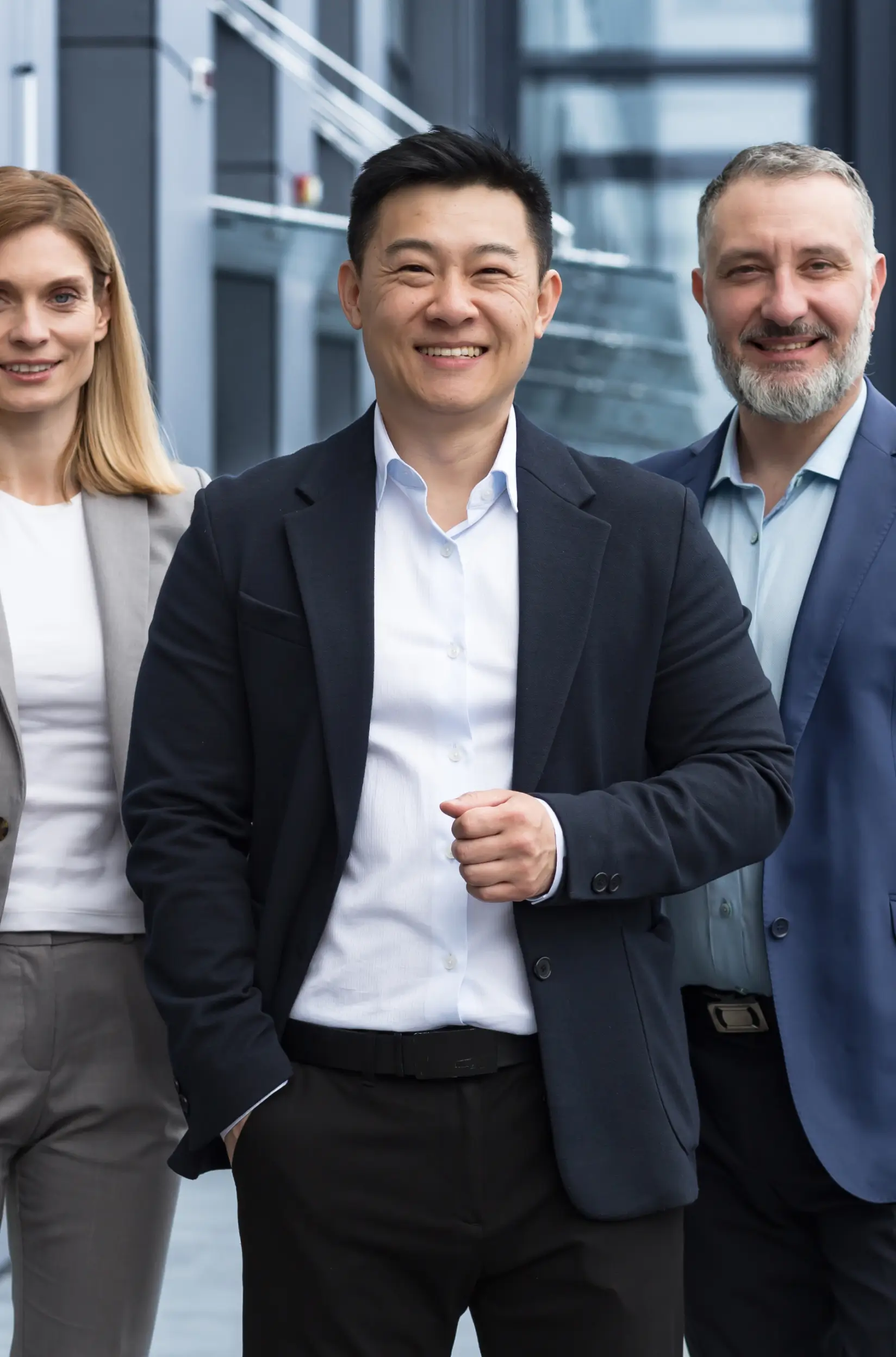 Drei Personen stehen in Anzug nebeneinander